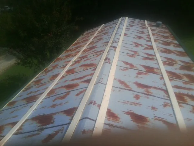 Rusted metal roof panels with new wood purlins before replacement — Storm Damage Roof Repair in Cohocton by Roofing Brothers