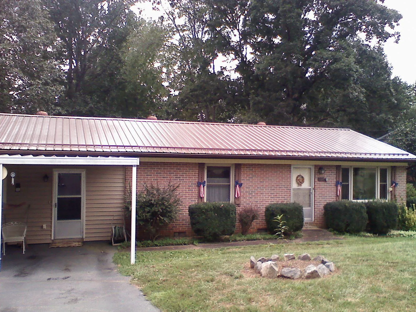 Bronze metal roof and carport on a brick ranch home — Roof Repair work by our crew in Cohocton